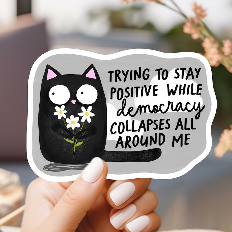 a person holding a sticker with a cat on it