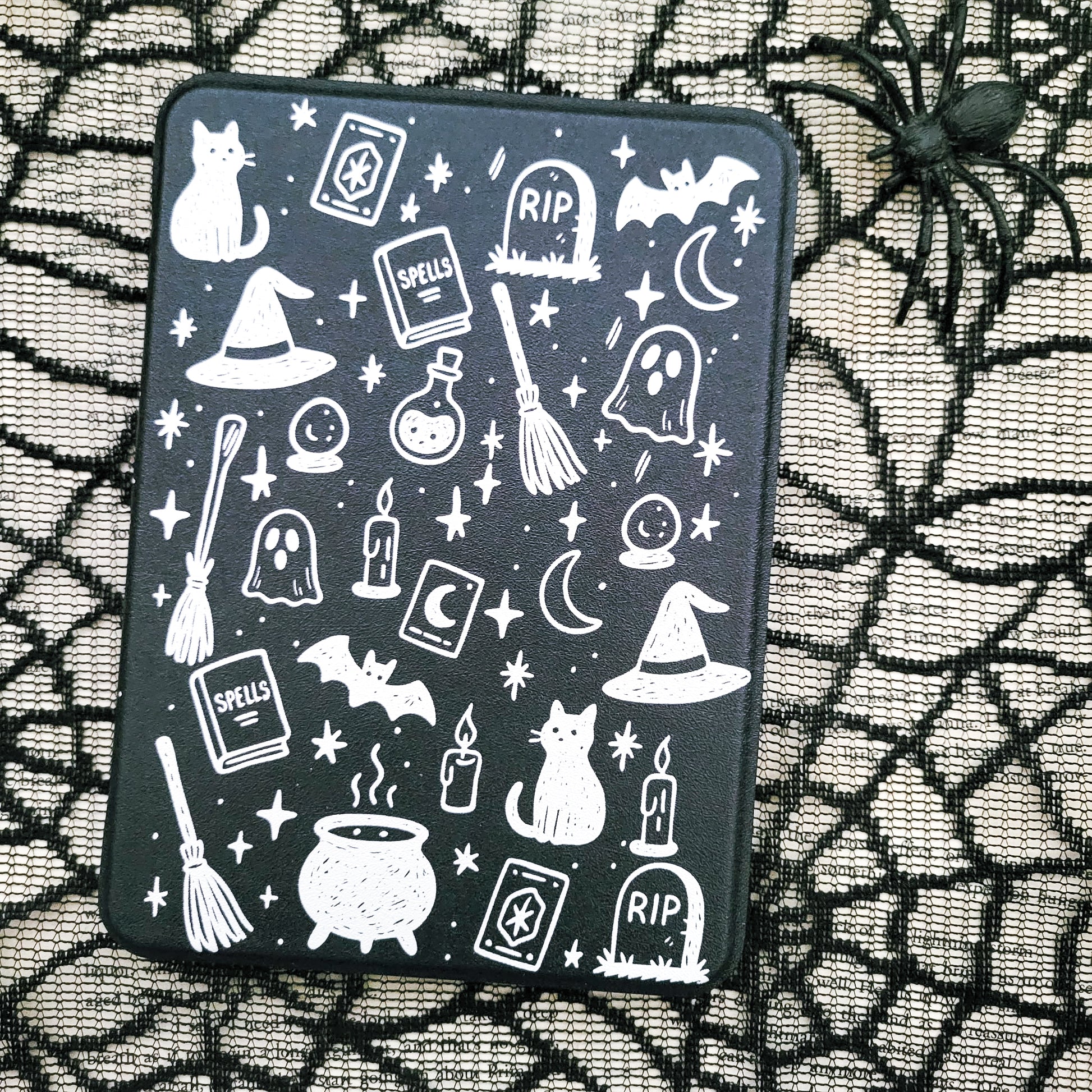 a black case with a Halloween-themed design on it, including various spooky and supernatural elements such as bats, skulls, ghosts, and a spider.