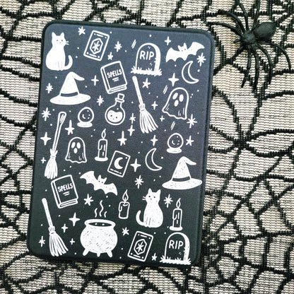 a black case with a Halloween-themed design on it, including various spooky and supernatural elements such as bats, skulls, ghosts, and a spider.