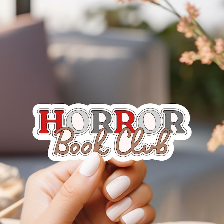 a person holding a sticker that says horror book club