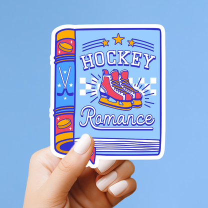 A hand holding a sticker with a hockey-themed design, including a pair of skates and the words "HOCKEY Romance" written on it.