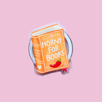 A sticker or decal depicting a book titled "Horny for Books" with a chili pepper illustration on the cover.