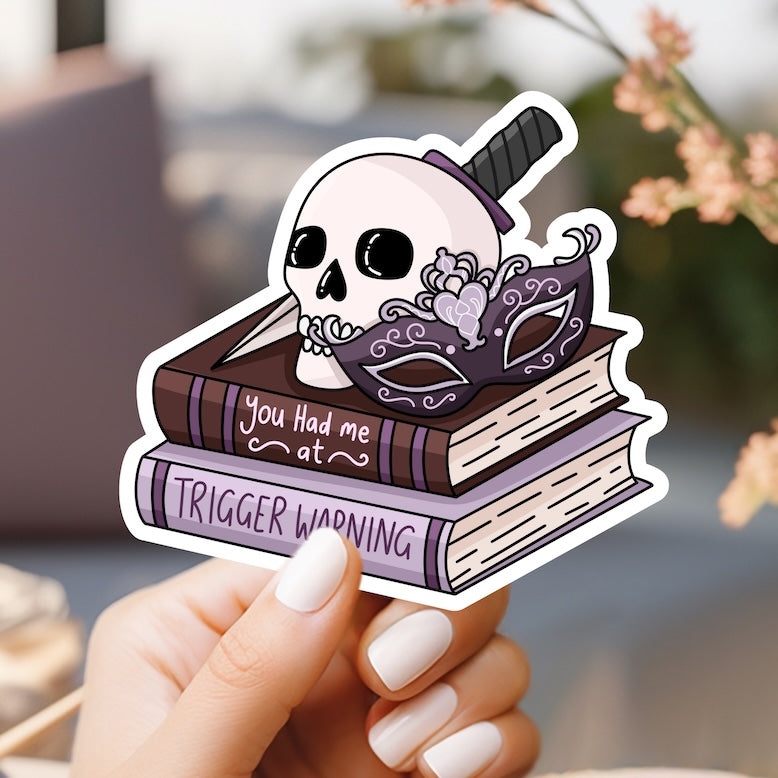 a person holding a sticker with a skull on top of a book