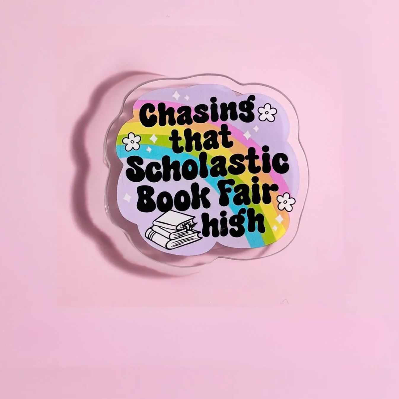 A sticker with the text "Chasing that Scholastic Book Fair high" against a pink background.