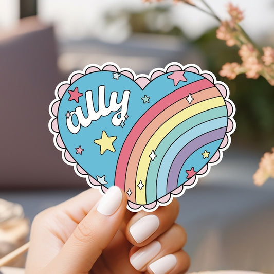 a person holding a sticker with a heart and a rainbow