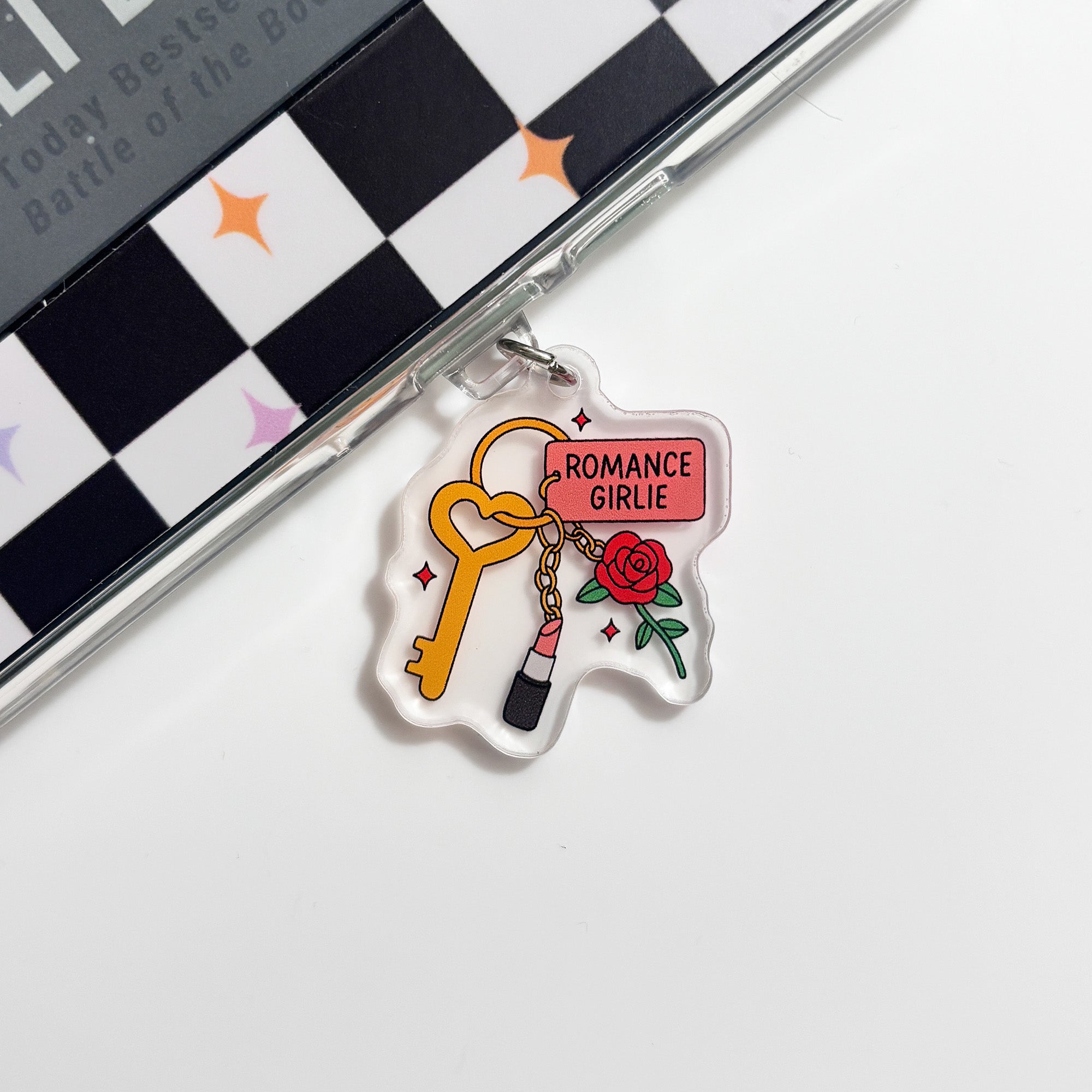 a clear plastic charm with a key and a rose, along with the text 