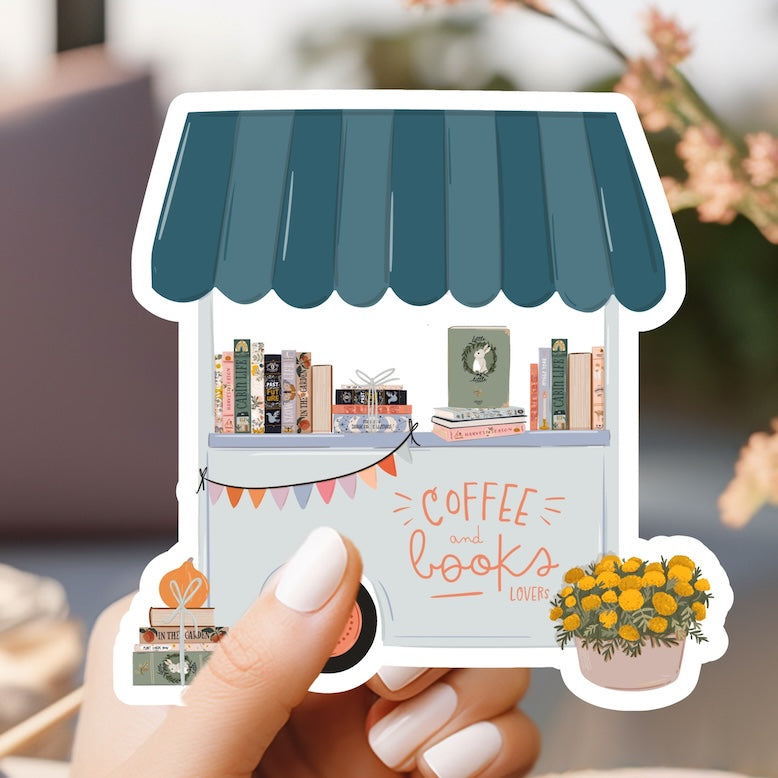 a hand holding a sticker of a coffee shop
