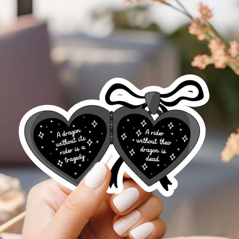 a hand holding a pair of heart shaped stickers