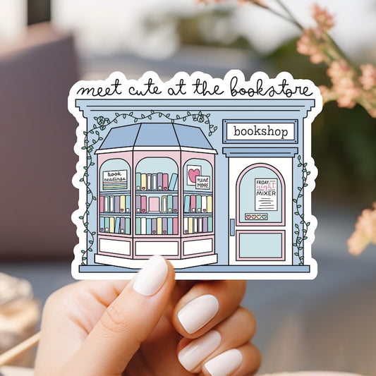 a person holding up a sticker with a book store on it