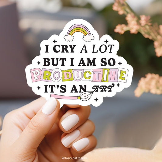A sticker with a white outline that says “A cry a lot but I’m so &#39; productive, it’s an art”. A quote from a Taylor Swift’s song, I Can Do It With a Broken Heart. The album is The Tortured Poets Department.