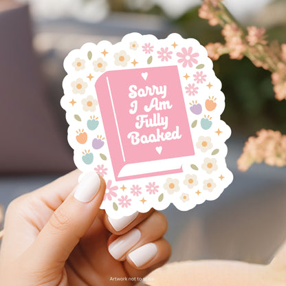 a person holding a pink and white sticker with a book on it