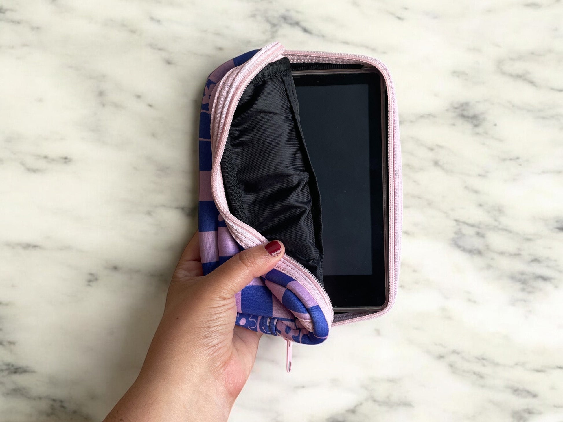 Interior photo of crossbody bag showing kindle inside as well as pockets