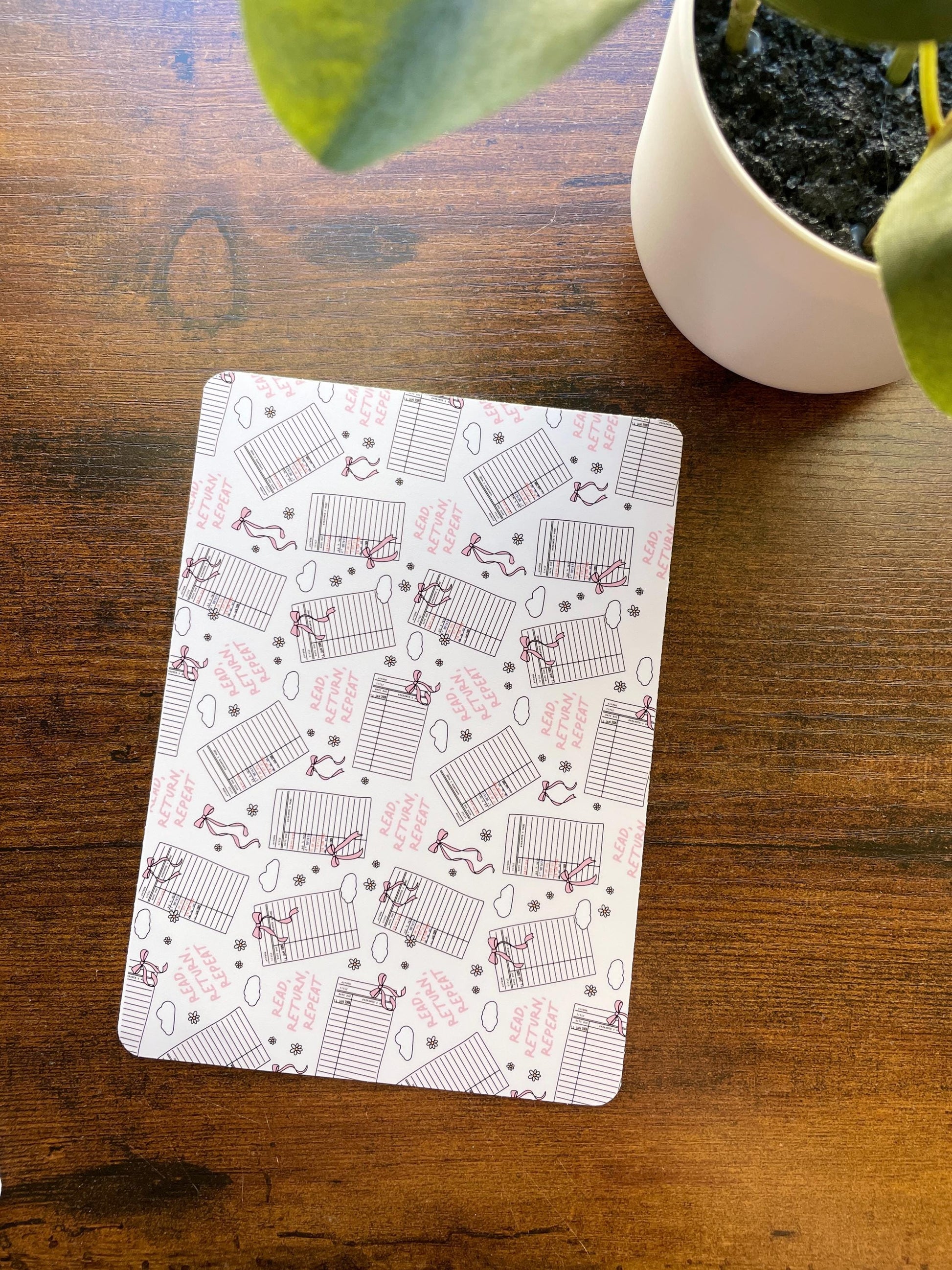 a potted plant sitting next to a white square coaster