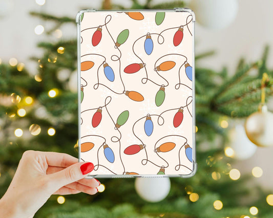 a hand holding a tablet with a christmas tree in the background