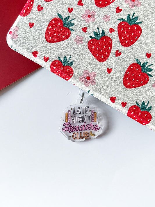 a red and white strawberry themed bag with a tag on it