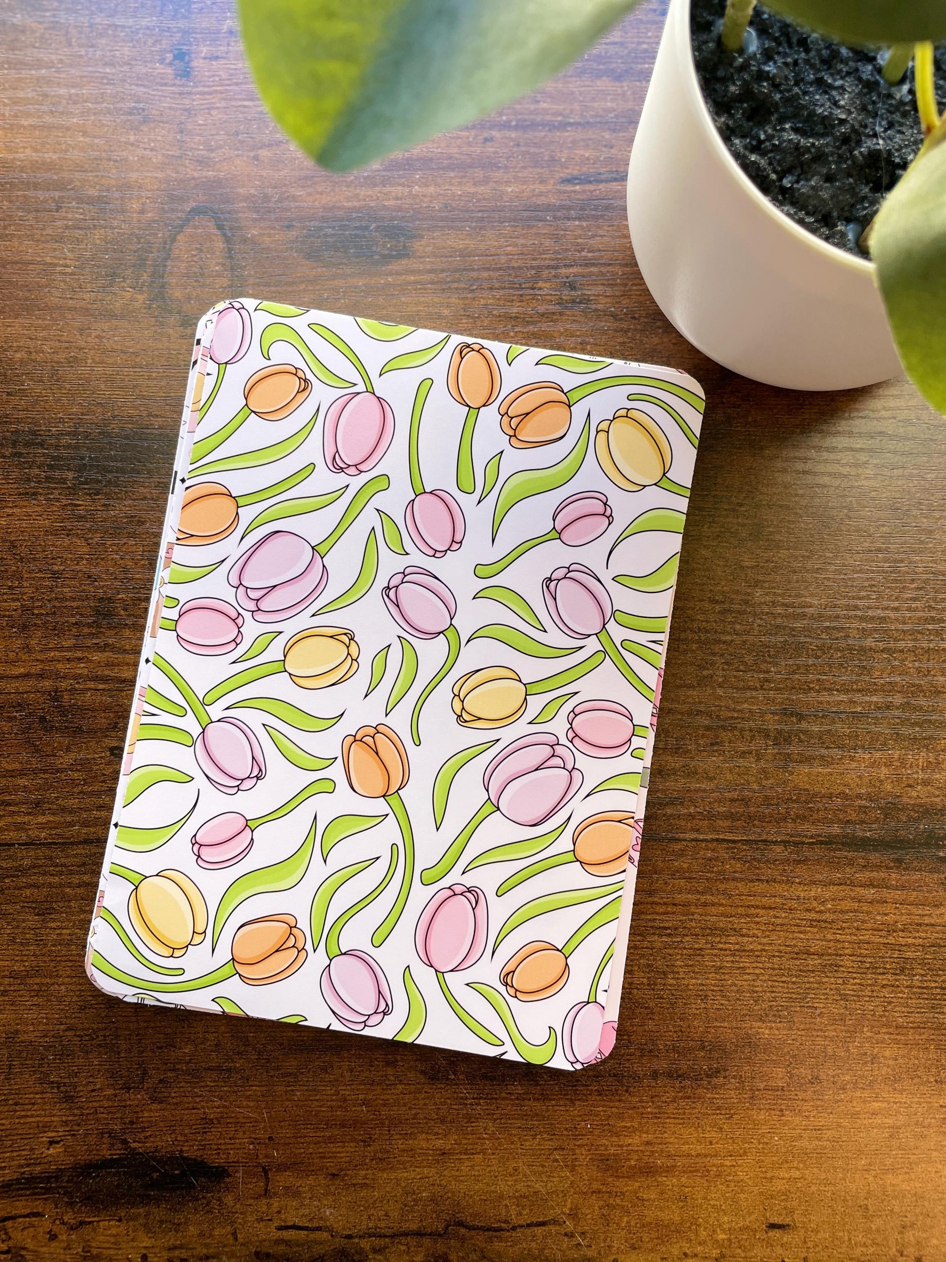 a potted plant sitting next to a notebook on a table