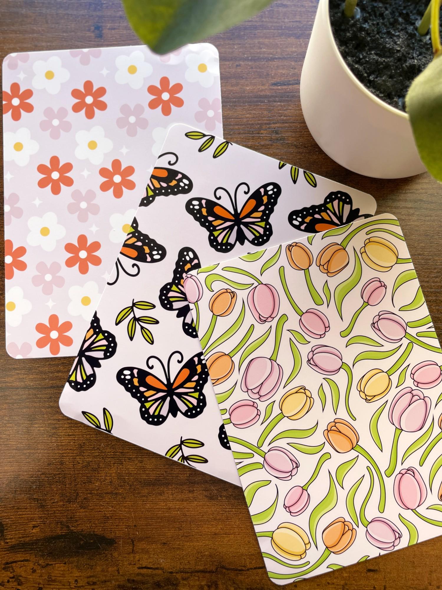 a potted plant sitting next to two butterfly coasters