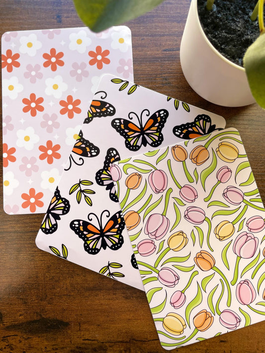 a potted plant sitting next to two butterfly coasters